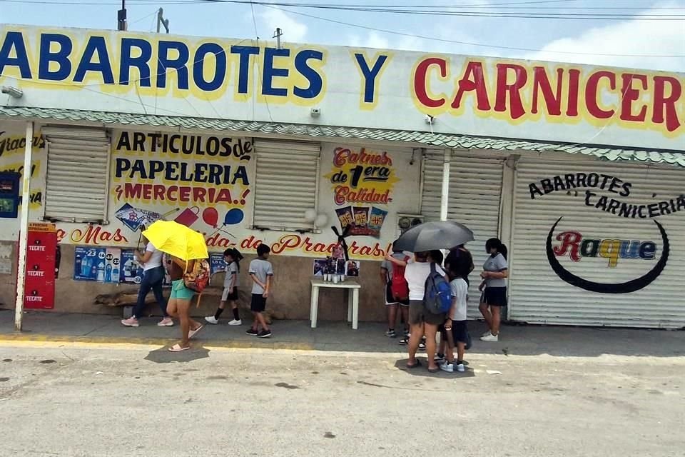 Vecinos montaron un altar con fotografías y veladoras afuera de la Carnicería y Abarrotes 'Raque', en memoria de las víctimas del accidente en Hualahuises.
