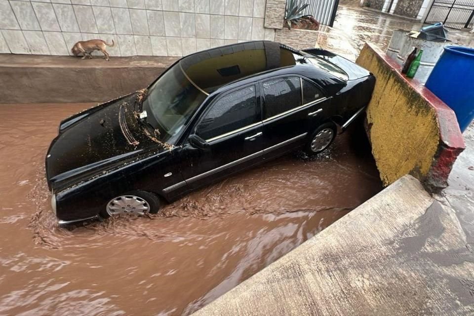 El auto que fue arrastrado por la corriente quedó varado sobre las calles Rivera del lago y Morelos.