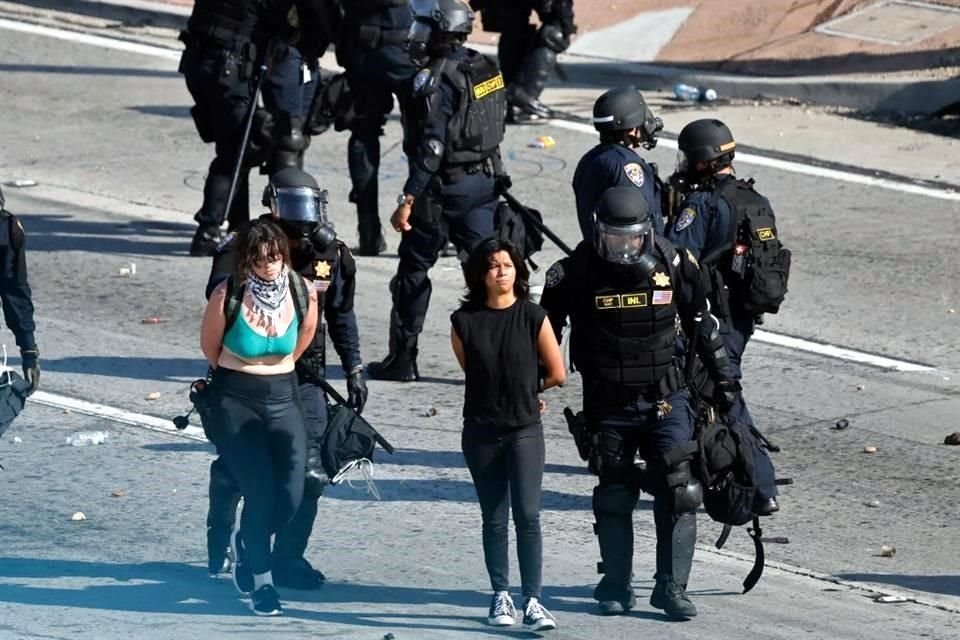 Agentes policiacos detienen a manifestantes  que bloqueaban la Autopista 101 en Los Angeles, California.