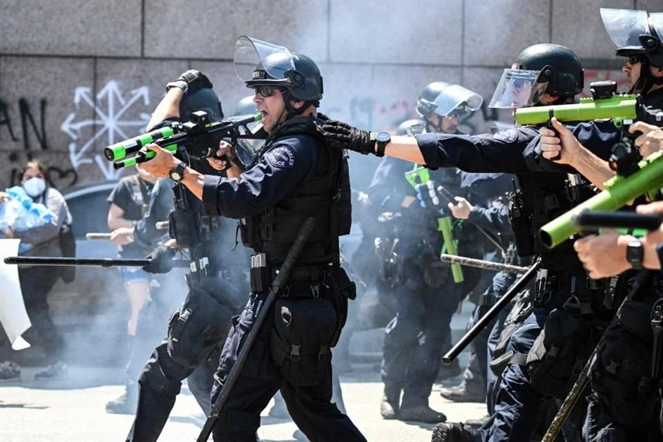Policías disparan municiones no letales contra manifestantes.