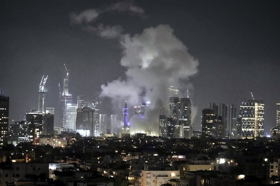 Se ve humo elevándose desde Tel Aviv luego de un aparente impacto de misil iraní en la zona.