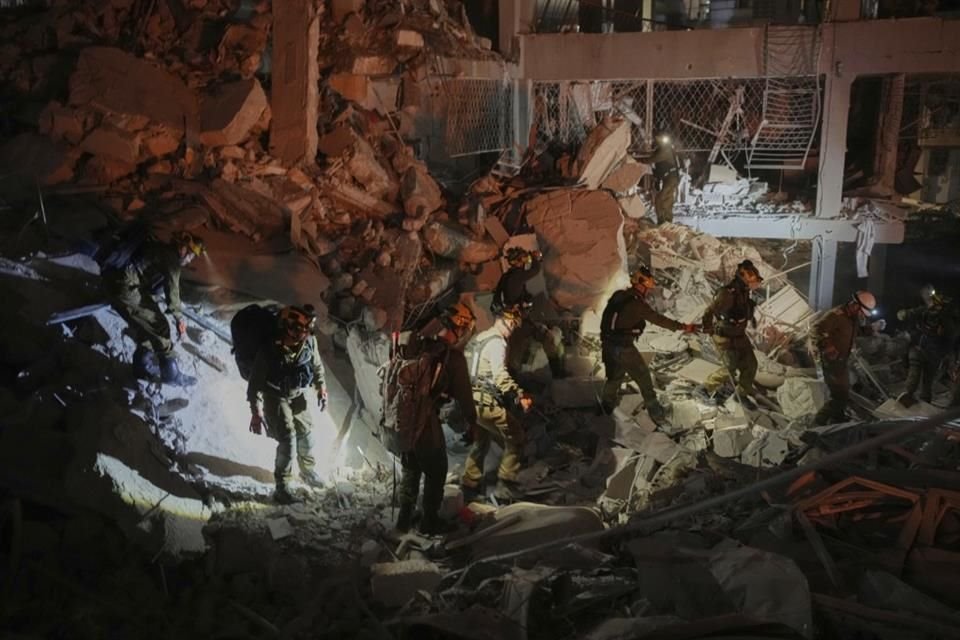 Fuerzas de seguridad israelíes inspeccionan un edificio destruido cerca de Tel Aviv que fue alcanzado por un misil disparado desde Irán, en la madrugada del domingo 15 de junio de 2025, tiempo local.