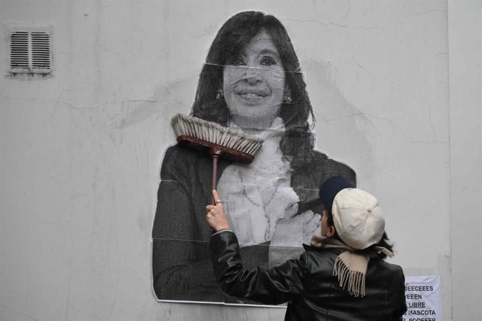 Una seguidora de la ex Presidenta Cristina Fernández pega un póster afuera de su residencia en Buenos Aires, el 17 de junio del 2025.