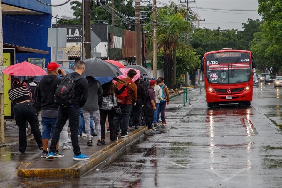 A primeras horas de la mañana, la lluvia tomó por sorpresa a personas y se hicieron largas filas para esperar el transporte público.