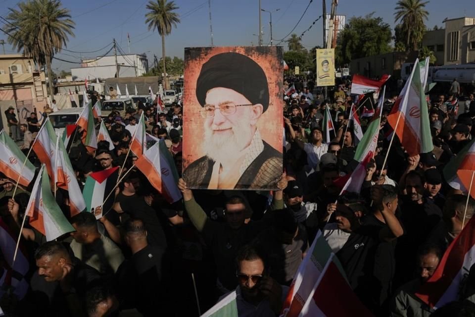 Con un retrato del Ayatolá, chiitas en Baghdad, Irak, hacen una manifestación de respaldo a Irán.