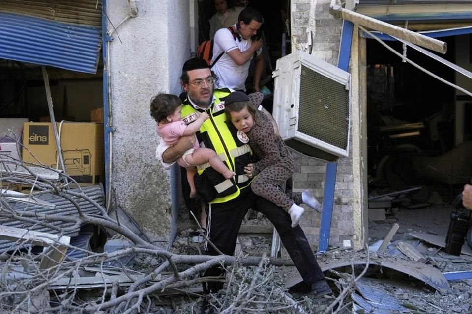 Un rescatista evacúa a dos niños en la ciudad de Haifa.
