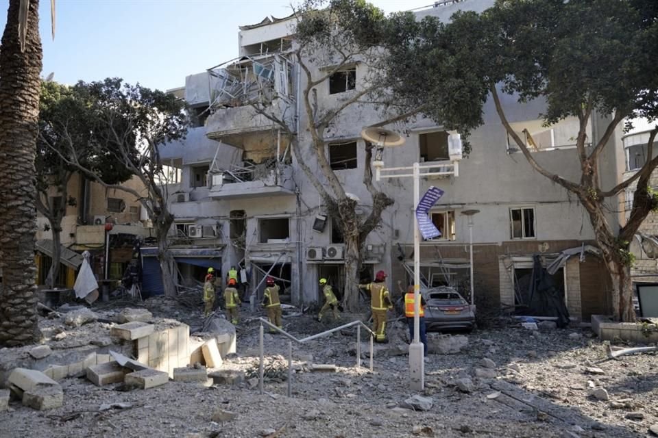 Bomberos inspeccionan el lugar donde impactó un misil lanzado desde Irán en Haifa, Israel.