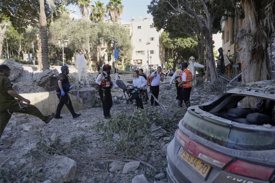 Rescatistas evacuan a residentes del lugar donde impactó un misil lanzado desde Irán en Haifa, Israel.