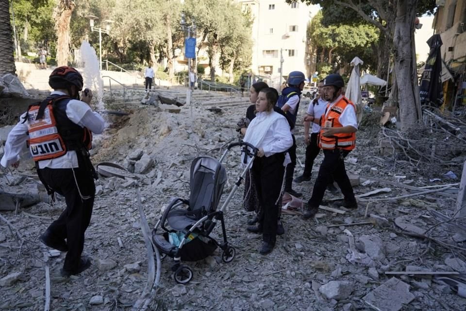 Rescatistas evacuan a residentes del lugar donde impactó un misil lanzado desde Irán en Haifa, Israel.
