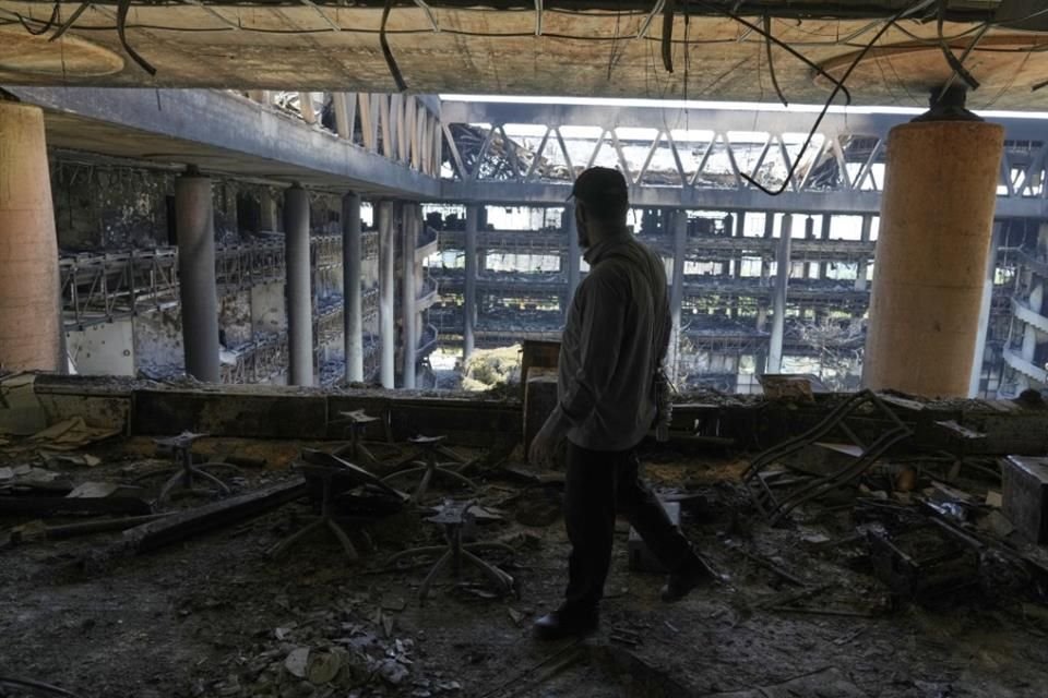 Un hombre camina por el interior de la sede de la Radiodifusión de la República Islámica de Irán, que sufrió importantes daños en un ataque.