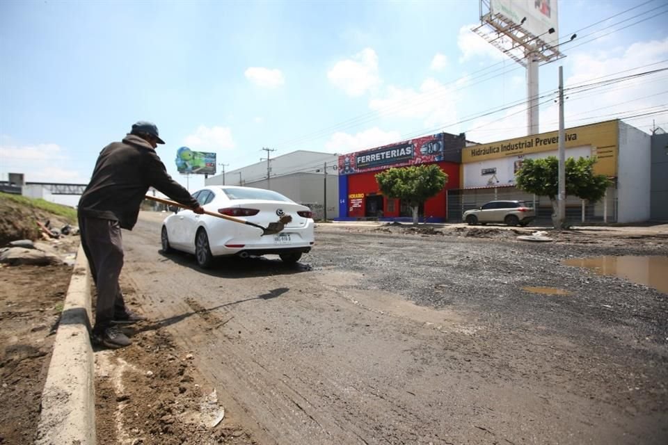 Dai lati del Periférico e della Calle del Panadero, la gente riempie le buche in cambio di qualche moneta.
