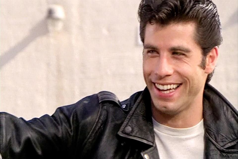 Travolta, quien interpretó al galán en la película musical original de 1978, lució una chamarra de cuero y una peluca peinada hacia atrás.
