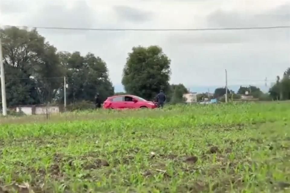 La camioneta roja, con placas de CDMX y un cuerpo en su interior dentro de bolsas negras, fue encontrada en Coronango, Puebla.