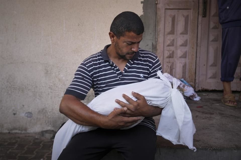Omar Meshmesh carga el cuerpo de su sobrina Aya, de 3 años, quien se encontraba entre las 10 personas que murieron en un ataque israelí mientras esperaba recibir suplementos alimenticios.