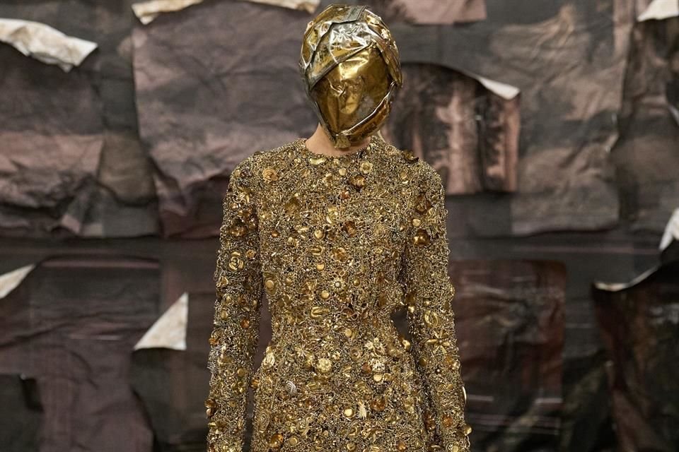 Sobresalen abrigos con hombros marcados y capas estructuradas, vestidos metálicos que simulan armaduras, túnicas transparentes y chaquetas ensambladas con texturas yuxtapuestas.