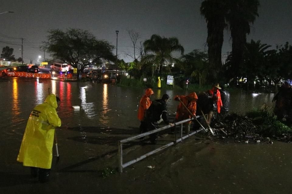 Bomberos de Tlajomulco desasolvaron la zona del canal para bajar el nivel del agua, los carros pudieran pasar y la gente pudiera ingresar a sus hogares.
