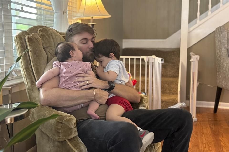 El veterano del Cuerpo de Marines de Estados Unidos, Adrian Clouatre, carga a su hija de 3 meses de edad, Lyn, y a su hijo de casi 2 años de edad, Noah.