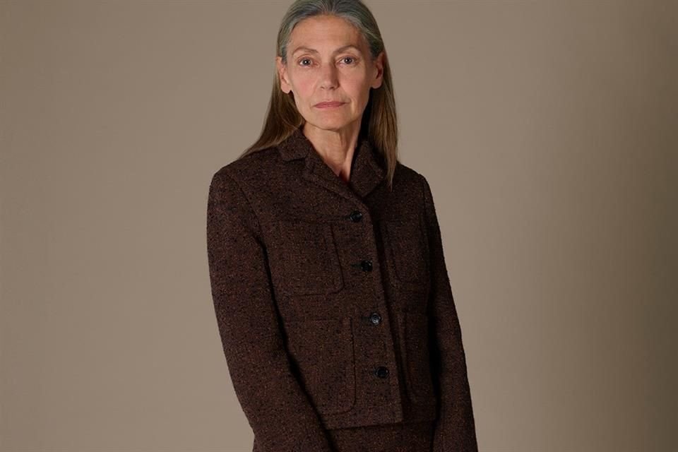 Otro de los atuendos que roban miradas, es un traje formal utilizado por una mujer de edad avanzada, con falda y suéter en tonos marrón oscuro, llevando solo un bolso de la marca como accesorio.