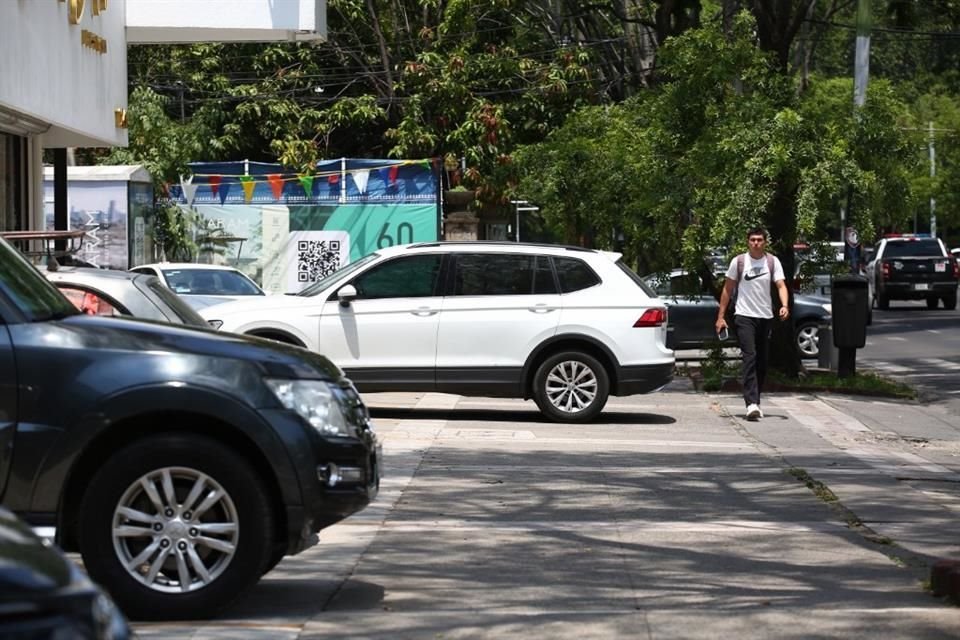Autos estacionados invadiendo la banqueta en Avenida Vallarta.