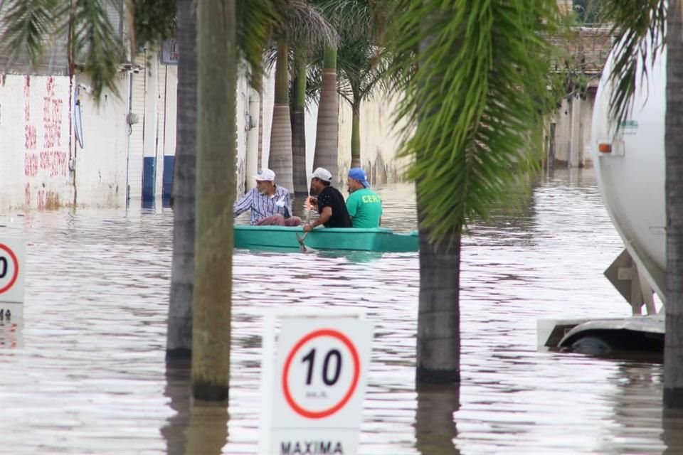 Christian, ayuda a gente con su lancha en la inundación sobre Adolf B Horn y 1 de Mayo en Tlajomulco de Zuñiga.