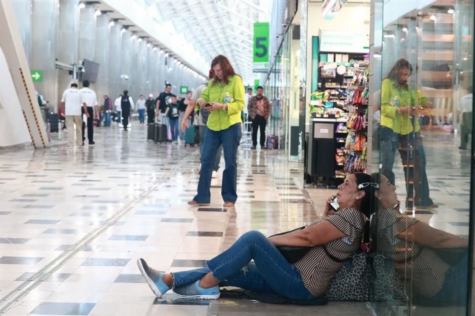 Aunque con menos gente, en la Terminal 1 también se observa a cientos de personas que, con sus maletas al lado, esperan información sobre la reprogramación de sus vuelos.
