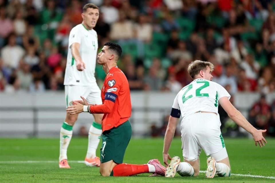 Cristiano Ronaldo (izq.), de Portugal, y el defensor Nathan Collins (der.), lamentan una jugada en el duelo entre sus selecciones.