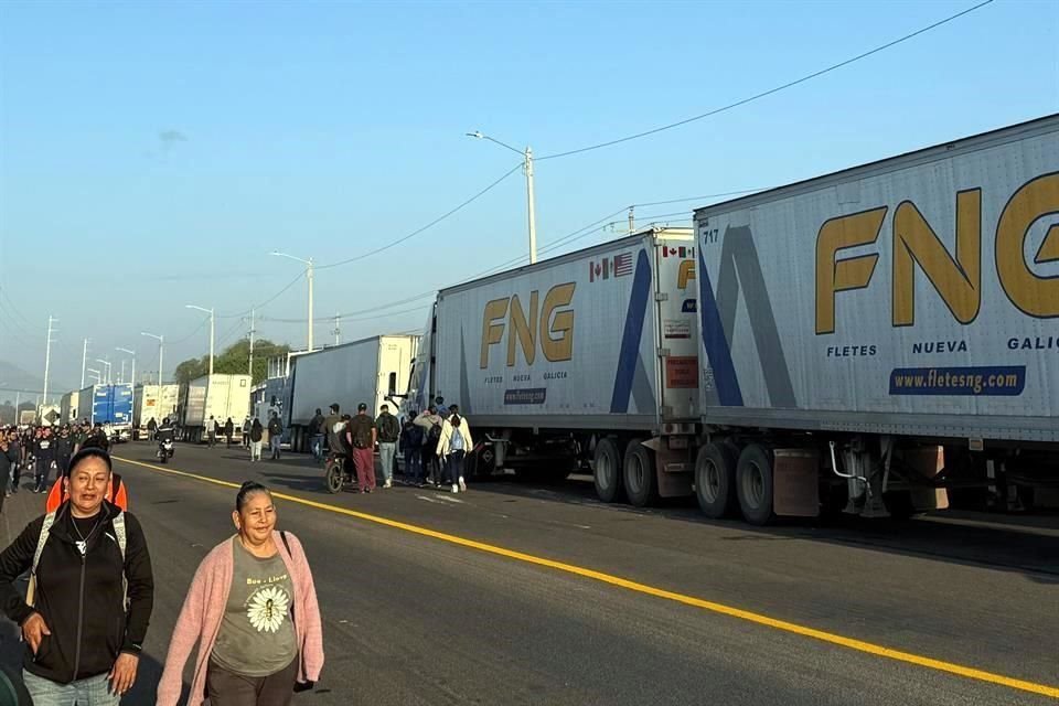 Trabajadores de la zona industrial de Tlajomulco tuvieron que caminar por el bloqueo en la carretera Tala-Santa Cruz de las Flores, a la altura de Laboratorios PiSA.