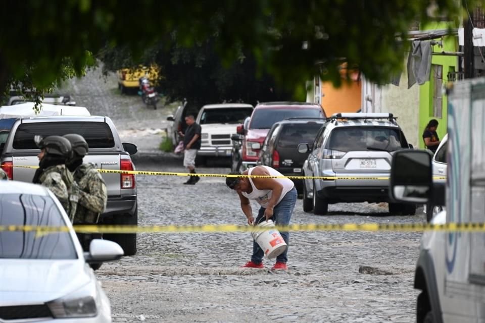 Un hombre aprovechó el cierre de la calle para ponerse a remendar un bache, al que le echó varias cubetadas de cemento, en lo que los peritos hacían los trabajos de campo.