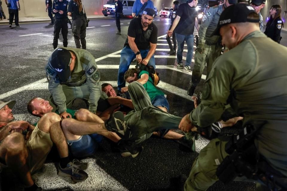 Policía retira a manifestantes que bloqueaban una vía.