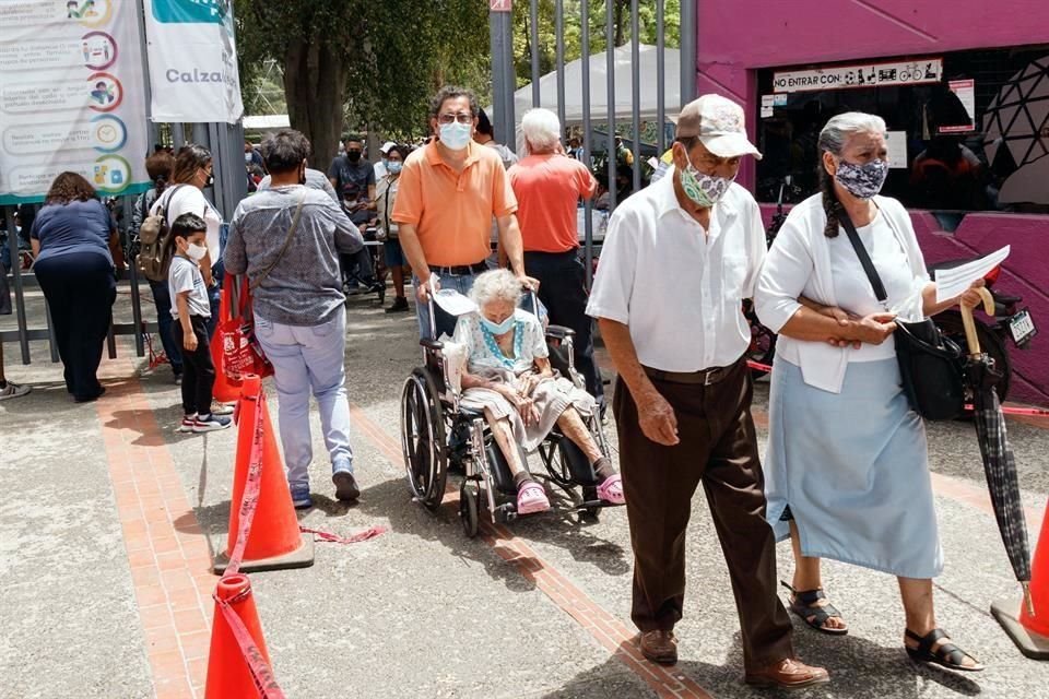 Adultos mayores salen del Parque Agua Azul después de que se les aplicó la vacuna.