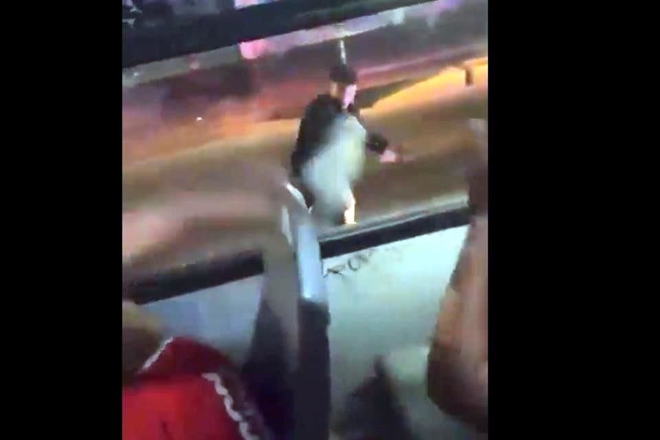 En el video se ve a un policía de Zapopan romper la ventana de un camión con aficionados a bordo tras arrojarles un ladrillo. 
