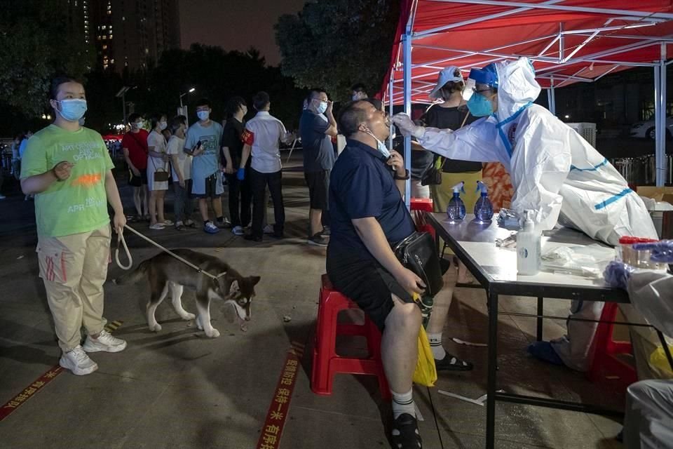 Residentes de Wuhan asisten a un centro de pruebas de Covid, luego de que las autoridades anunciarán que harían exámenes a toda la población.